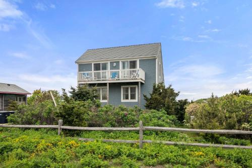 a house on a hill with a fence at Walk to Water-Dazzling Sunsets on the Bay in Truro