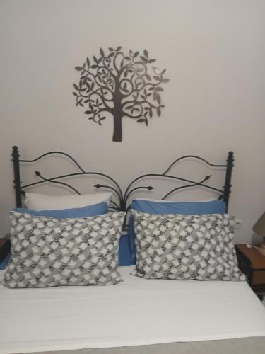a bedroom with a bed with a tree on the wall at Artemis Bakery’s House 1 in Adamas