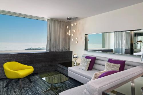a living room with a couch and a yellow chair at The Wade in Chicago