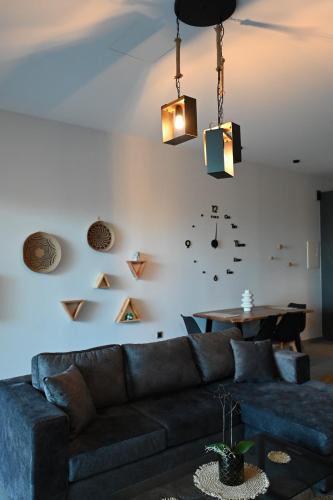 a living room with a couch and a clock on the wall at George's Soul in Porto Heli