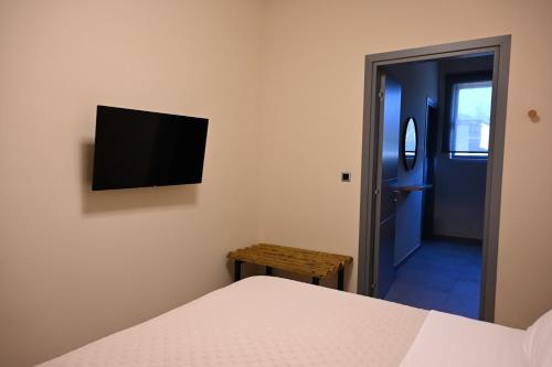 a bedroom with a bed and a tv on the wall at George's Soul in Porto Heli