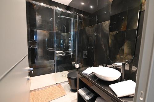 a black bathroom with a sink and a shower at George's Soul in Porto Heli