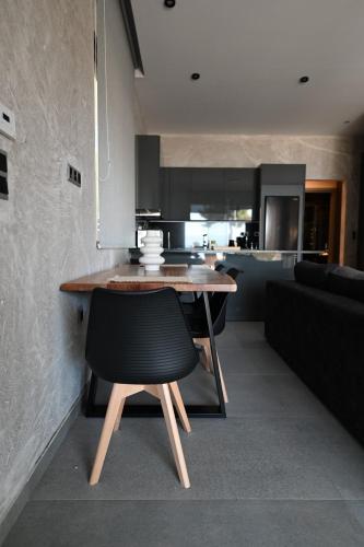 a kitchen with a wooden table and a black chair at George's Soul in Porto Heli