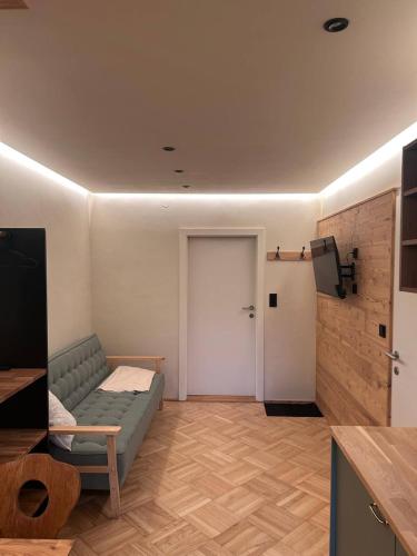 a living room with a couch and a door at Pension Schindlau in Scharnstein