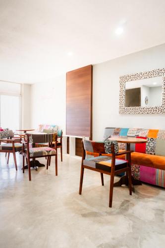 a room with a bunch of chairs and tables at Hotel Urban 101 in Chetumal
