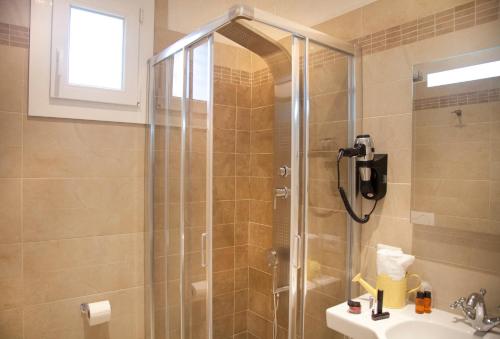 a shower with a glass door in a bathroom at Hotel Britannia Rimini Marina centro in Rimini