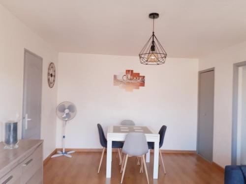 une salle à manger avec une table et des chaises blanches dans l'établissement residence les Amaryliss, à Fréjus