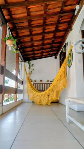 a hammock on the porch of a house at Pousada Du’Forte in Praia do Forte