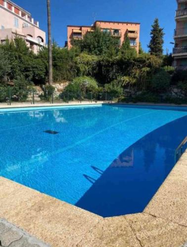 une grande piscine bleue devant un immeuble dans l'établissement Bright 2-room apartment - rooftop terrace - swimming pool, à Vallauris