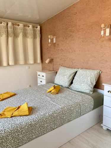 - une chambre avec un lit et des serviettes jaunes dans l'établissement Bright 2-room apartment - rooftop terrace - swimming pool, à Vallauris