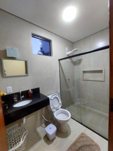 a bathroom with a toilet and a sink and a shower at Paraíso nas férias in Porto Seguro