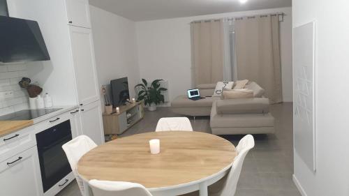 Il dispose d'une cuisine et d'un salon avec une table et des chaises en bois. dans l'établissement Maison neuve avec jardin, à Lons