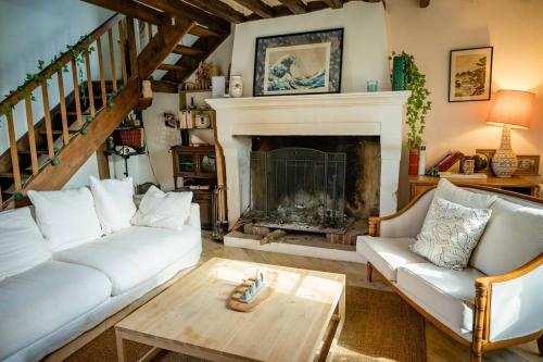 un salon avec un canapé blanc et une cheminée dans l'établissement Chastenay - Séjour à Ouanne, à Ouanne