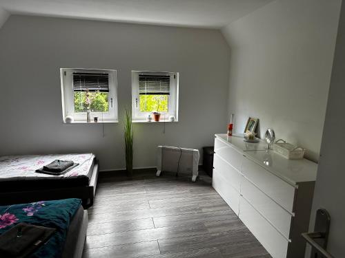 RüthenにあるWohnung in Kallenhardter Heideのベッドルーム1室(ベッド1台、シンク、窓2つ付)