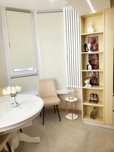 a room with a table and a chair and a window at Luxury design Apartment in Chişinău
