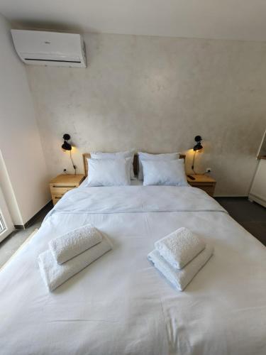 a large white bed with two white towels on it at Apartman Holiday 3 in Veliko Gradište
