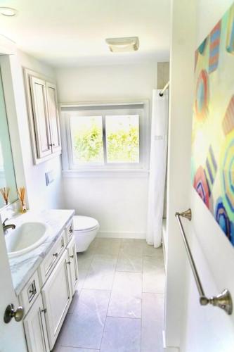 a bathroom with a sink and a toilet and a window at Charming Beach Cottage in Westbrook