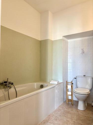 a bathroom with a white tub and a toilet at HÖTEL U SANTA MARIA in Olmeto
