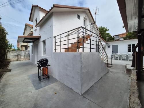 a white house with a grill in front of it at La casita de Hortensia in Nigrán