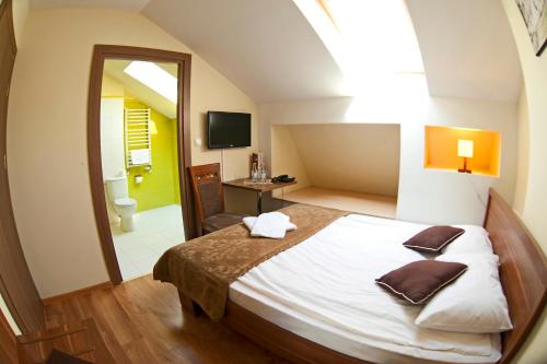 a bedroom with a large bed and a bathroom at Pensjonat Szajna Spa in Rymanów-Zdrój