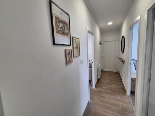 a hallway with white walls and wood floors and a bedroom at La casita de Hortensia in Nigrán