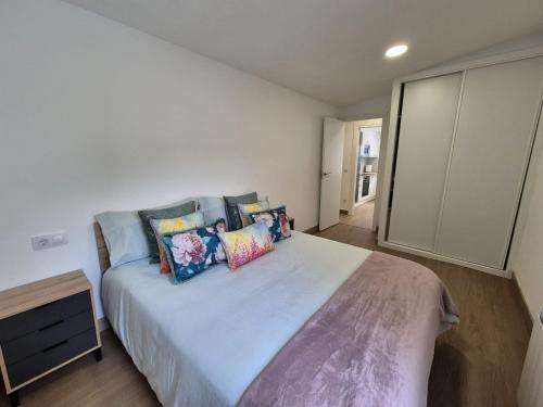 a bedroom with a large bed with colorful pillows at La casita de Hortensia in Nigrán