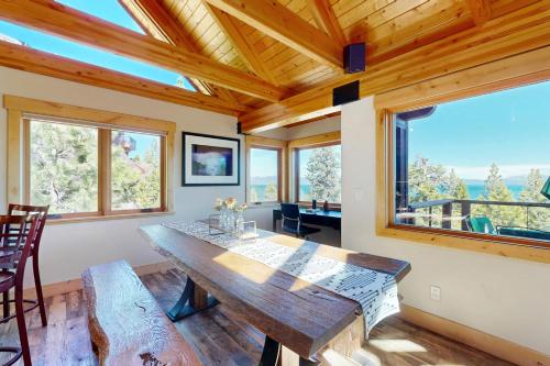 a dining room with a wooden table and large windows at Summit and Shore Hideaway in Tahoe City