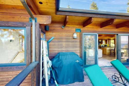 a cabin with green chairs on a deck with sliding glass doors at Summit and Shore Hideaway in Tahoe City