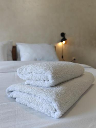three towels are stacked on top of a bed at Apartman Holiday 3 in Veliko Gradište