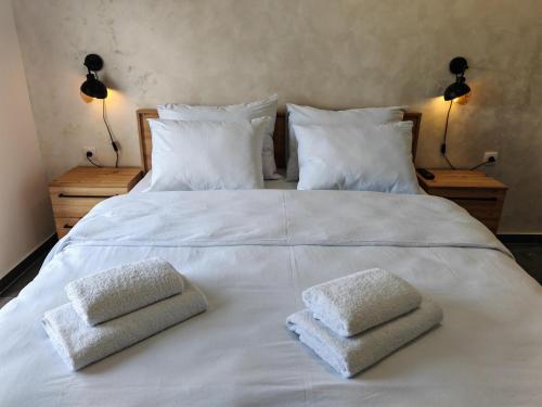 a white bed with two towels on top of it at Apartman Holiday 3 in Veliko Gradište