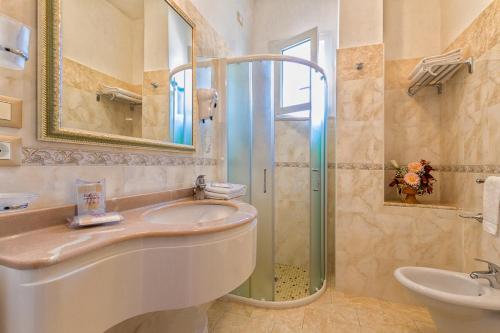 a bathroom with a shower and a sink and a mirror at Hotel Rosa Maria Elite in Bellaria-Igea Marina
