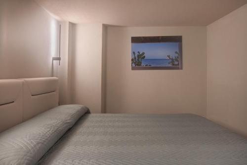 a bedroom with a bed and a painting on the wall at Zen escape Sicilia in San Gregorio di Catania