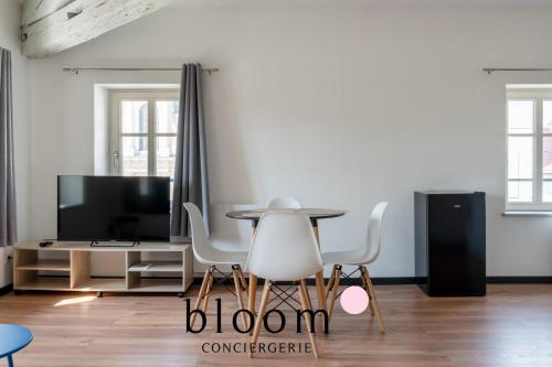 - un salon avec une table, des chaises et une télévision dans l'établissement L'étoile Place du Marché central, à Nancy