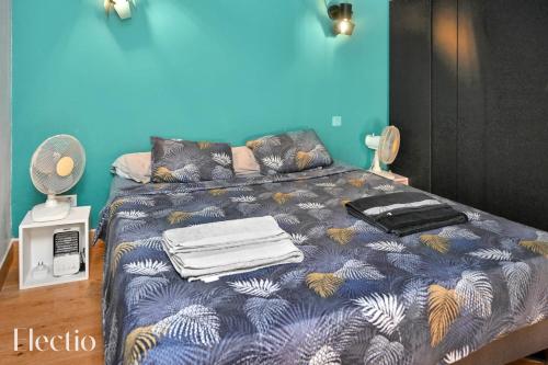 une chambre avec un lit avec un mur bleu dans l'établissement Apartment Petite Fusterie I Electio, à Avignon