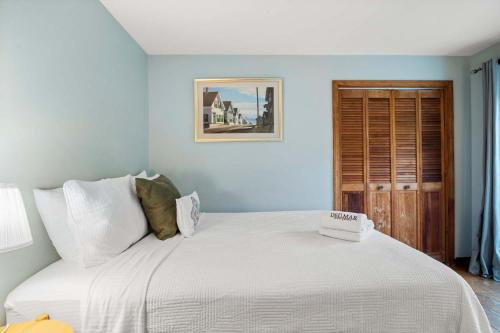 a bedroom with a large bed with white sheets at Walk to Beach w Roof-Level Deck in Truro