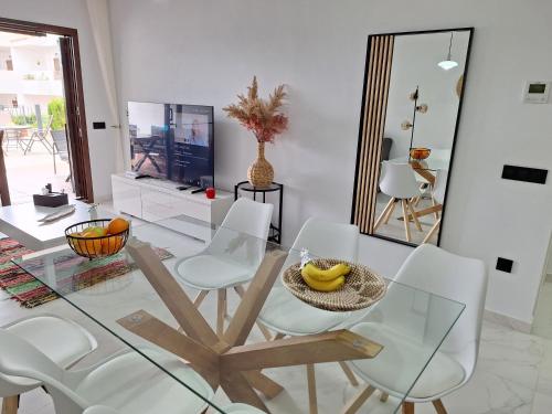 a dining room with a glass table and white chairs at Cocoonly in San Juan de los Terreros