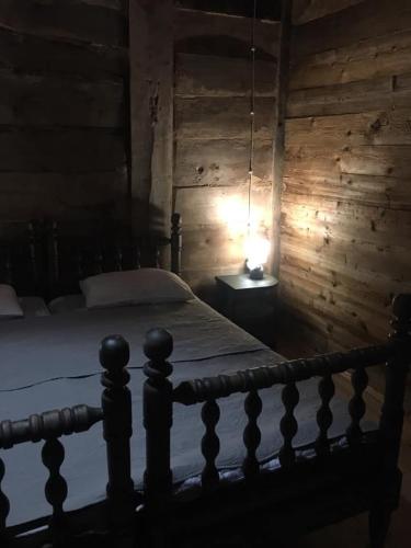 a bedroom with a bed with a lamp on a table at Thea's Ethnographic Guest House in Nap'ich'khovo