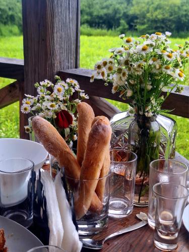 a table with a vase of flowers and bread at Thea's Ethnographic Guest House in Nap'ich'khovo
