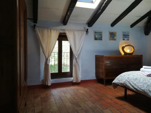 a bedroom with a bed and a window at Casale immerso nella natura in Castel dʼAiano