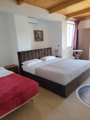 a bedroom with two beds and a window at Lahuta e Vjeter Agroturizem in Laç