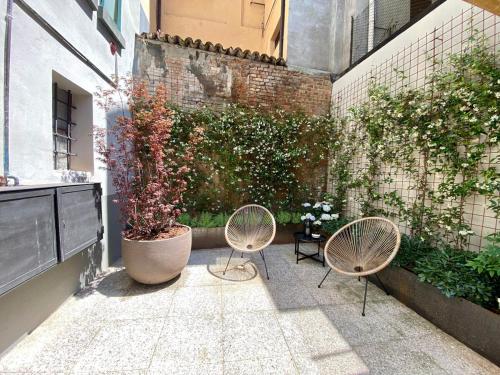 a patio with two chairs and a plant at Zenone monolocale Reggio Emilia Historic Center in Reggio Emilia