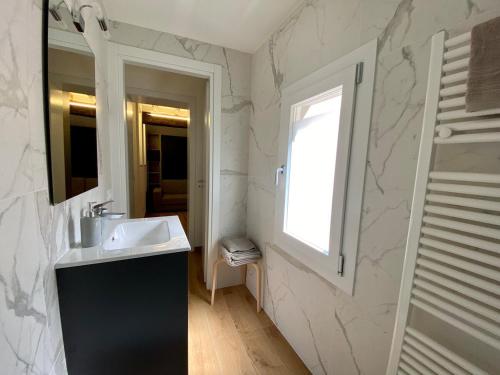 a bathroom with a sink and a mirror and a window at Zenone monolocale Reggio Emilia Historic Center in Reggio Emilia