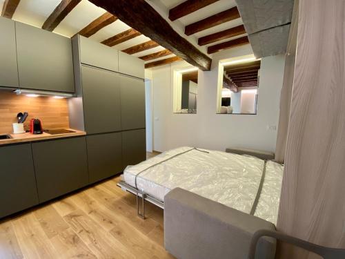 a bedroom with a bed and a kitchen in it at Zenone monolocale Reggio Emilia Historic Center in Reggio Emilia