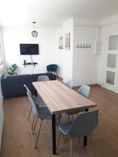 un salon avec une table et des chaises en bois dans l'établissement Appartement quartier du minck, à Calais
