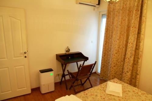 a room with a desk and a table and a chair at Mimoza Apartment in Ðenovići