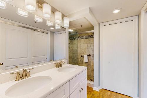 Un baño con dos lavabos y un espejo grande. en Triton's Trumpet C 303, en Ocean City