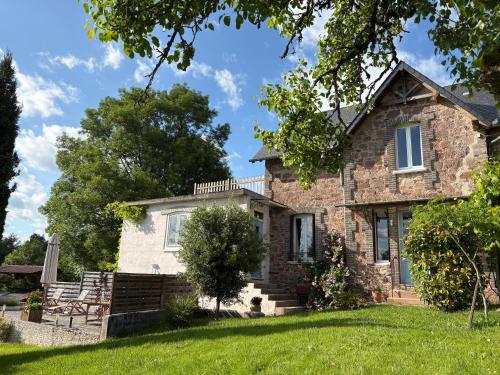 an old stone house with a green lawn at Maison La Chapelle Bellevue in Saint-Solve