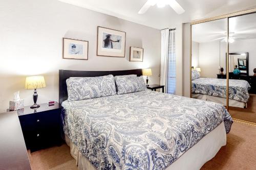 a bedroom with a large bed and a mirror at Island Sands Resort 107 in Wailuku