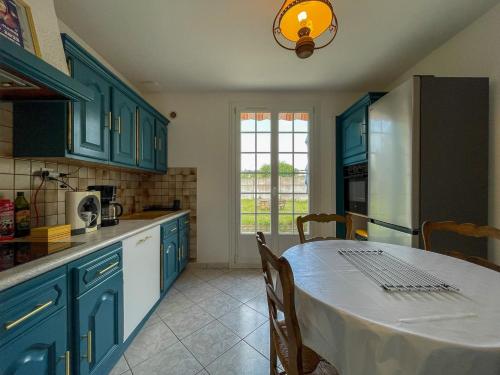 a kitchen with blue cabinets and a table with a white table cloth at Ti maeronez in Paimpol