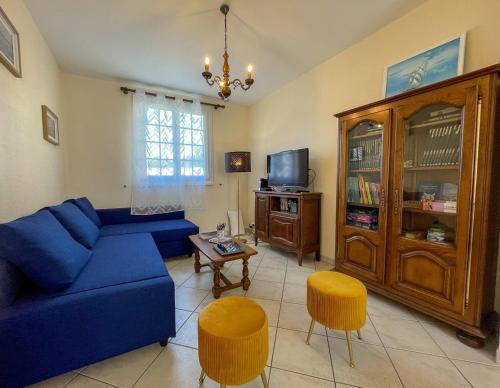 a living room with a blue couch and a tv at Ti maeronez in Paimpol